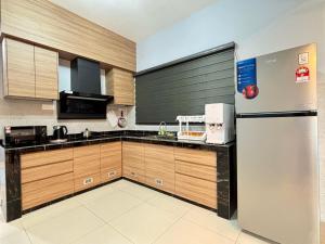 a kitchen with a refrigerator and wooden cabinets at The Paloh Town Suites 4R2B with 2 carpark by IWH Suites in Ipoh +23 photos