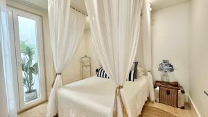 a bedroom with a canopy bed with a window at Ana´s House in Setúbal