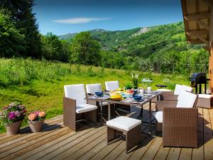 une terrasse en bois avec une table et des chaises dessus dans l'établissement Chalet Pajules - OVO Network, à Le Fey