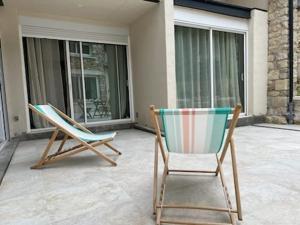two chairs sitting on a patio in front of a house at Studio Les Hauteurs de Juziers in Juziers