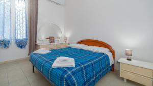 a bedroom with a bed with a blue plaid blanket at Don Leandro's House by Rentbeat in Civitavecchia +17 photos