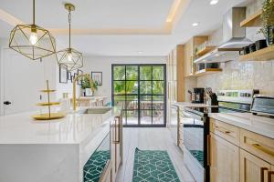 a kitchen with white countertops and a large window at Villa Verde Miami in Miami