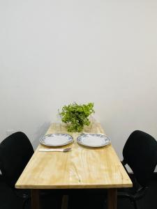 a wooden table with two plates and a plant on it at Misty Mountain Lodge in Kegalle
