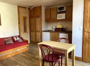 a kitchen with a table and chairs and a couch at Studio cosy à La Plagne-Tarentaise, 20 m² + vue sur montagne in La Plagne Tarentaise