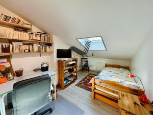 ein Schlafzimmer mit einem Bett, einem Schreibtisch und Bücherregalen in der Unterkunft Le Ferney - Proche du centre-ville et des thermes in Rochefort