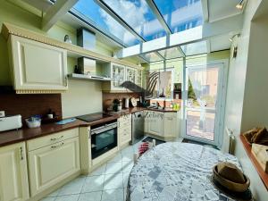 eine Küche mit weißen Schränken und einem großen Dachfenster in der Unterkunft Le Ferney - Proche du centre-ville et des thermes in Rochefort