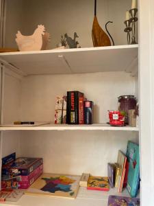 a book shelf with books and other items on it at Ma maison au cœur de la ville in Bergues