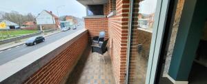 a bench on the side of a building with a street at Les studios de la Fontaine in Hornu