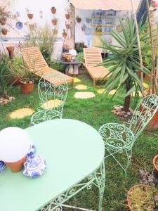 a table and chairs in a garden with a table and chairs at Beach House Babylon guest house with kitchenette and garden in Torreira