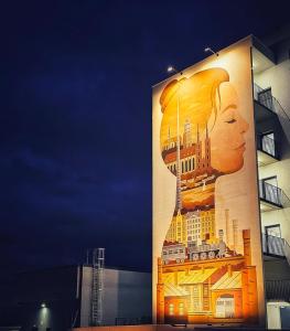 a building with a painting of a woman on it at Apartament Wrocław Promenady in Wrocław