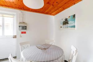 una sala da pranzo bianca con tavolo e sedie di Charming house in Praia do Almoxarife with sea view. a Praia do Almoxarife