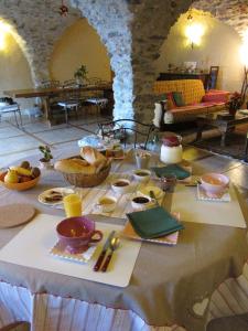 - une table avec de la nourriture dans une pièce en pierre dans l'établissement Le Clos de Lumière, à La Roche-des-Arnauds