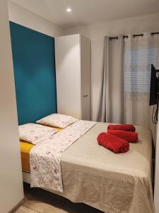 een slaapkamer met een bed met twee rode kussens erop bij Appartement 80 m2 avec jardin - 50m de la plage TIKI in Saint-Raphaël