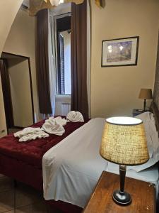 a bedroom with a bed with a lamp and a mirror at Hotel Giubileo in Rome