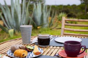 a table with a cup of coffee and a plate of food at Monte da Urze Aljezur - Agroturismo in Aljezur