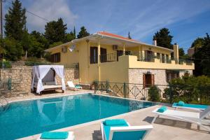 a villa with a swimming pool in front of a house at Buena Vista Villa - Amazing sea view in Lygia