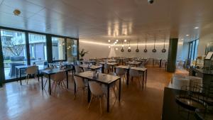 a restaurant with tables and chairs in a room at Hotel De la Paix in Lucerne