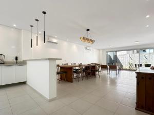 a kitchen and dining room with a table and chairs at 100 metros da praia - Condomínio - 3 suítes - Churrasqueira in Guarujá