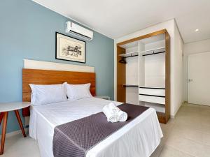 a bedroom with a bed with a towel on it at 100 metros da praia - Condomínio - 3 suítes - Churrasqueira in Guarujá +27 photos