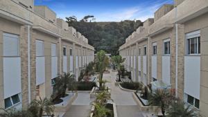 an empty courtyard of a building with palm trees at 100 metros da praia - Condomínio - 3 suítes - Churrasqueira in Guarujá
