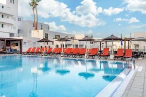 a large swimming pool with chairs and umbrellas at Terrazza Luxury Costa Adeje in Adeje