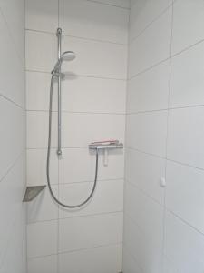 a shower in a bathroom with white tiles at Wohnung 2 in Haselünne +1 photo
