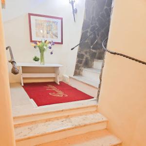 a stairway with a vase of flowers on a red carpet at Hotel Giubileo in Rome +67 photos