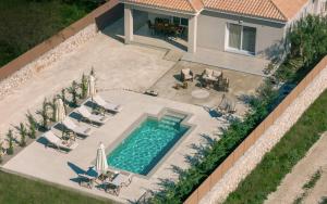 an overhead view of a swimming pool with chairs and umbrellas at Villa Nicoldia with private pool near Laganas in Laganas