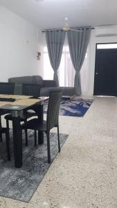 Una sala de estar con una mesa y sillas y un sofá. en Aman 2 Homestay Senawang Musliim only, en Seremban