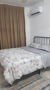 Un dormitorio con una cama con un edredón blanco. en Aman 2 Homestay Senawang Musliim only, en Seremban