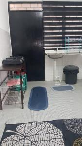 cocina con nevera negra y colchonetas azules en el suelo en Aman 2 Homestay Senawang Musliim only, en Seremban