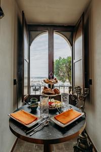 a table with food on it with a window w obiekcie Palazzo Giunta - Porta Marina Ortigia w Syrakuzach +37 zdjęć