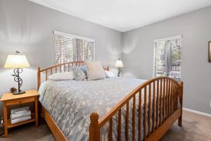 - une chambre avec un lit en bois et 2 fenêtres dans l'établissement Pinecone Escape - Close to Lake and Slopes, à Big Bear City