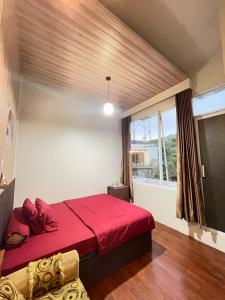 a bedroom with a red bed and a window at Hotel Bintang Sikunir in Kejajar +30 photos