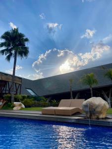 a swimming pool with a couch and a palm tree at Villa Bromo in Kasri