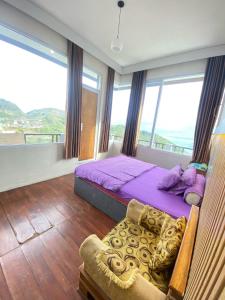a bedroom with a purple bed and a chair at Hotel Bintang Sikunir in Kejajar