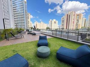un balcon avec des chaises bleues et une table et quelques bâtiments dans l'établissement Apartamento São Paulo Tatuapé, à São Paulo
