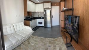 un salon avec un canapé blanc et une cuisine dans l'établissement Apartamento São Paulo Tatuapé, à São Paulo