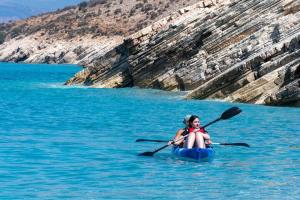 a woman sitting in a kayak in the water at Apartments Salai in Lukovë