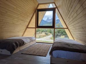 ビージャ・セロ・カスティージョにあるOUTSCAPE l Preciosa Cabaña en Villa Castilloの大きな窓のある部屋にベッドが2つある