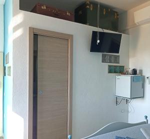 a room with a door and a tv on the wall at B&B Eleonora D'Arborea, Centro Storico in Posada