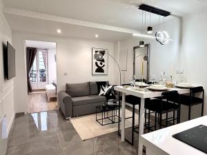 een keuken en woonkamer met een bank en een tafel bij Résidence Auguste Comte - avec Balcon - Cœur de Dijon in Dijon