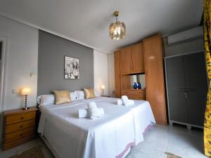 a bedroom with a large bed with white sheets at Bungalow Malibu Complex Doa Pepa- Rojales in Ciudad Quesada +29 photos