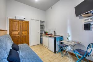 a living room with a blue couch and a kitchen at Studio proche centre ville in Sarlat-la-Canéda