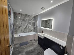 un bagno con lavandino, vasca e WC di Bramley Suite - The Apple Barn a Pettistree Altre 21 foto
