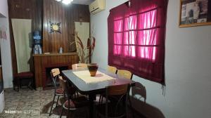 a table and chairs in a room with a red window at la morada in General Alvear