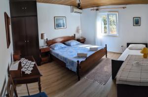 a bedroom with a bed and a table and a window at Marina Slano apartment in Slano