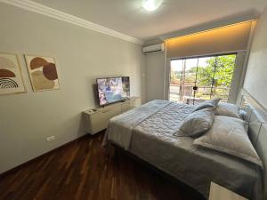 a bedroom with a large bed and a window at Sobrado, 4 Quartos, Piscina, até 12 pessoas in Foz do Iguaçu +49 photos