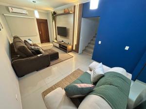 a living room with a couch and a tv at Sobrado, 4 Quartos, Piscina, até 12 pessoas in Foz do Iguaçu