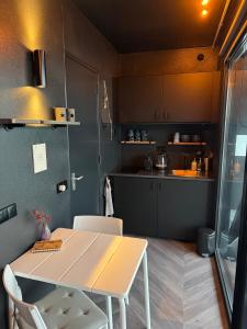 eine kleine Küche mit einem Tisch und Stühlen in einem Zimmer in der Unterkunft Wohnboot 'TinyFloat' in Andijk IJsselmeer in Andijk